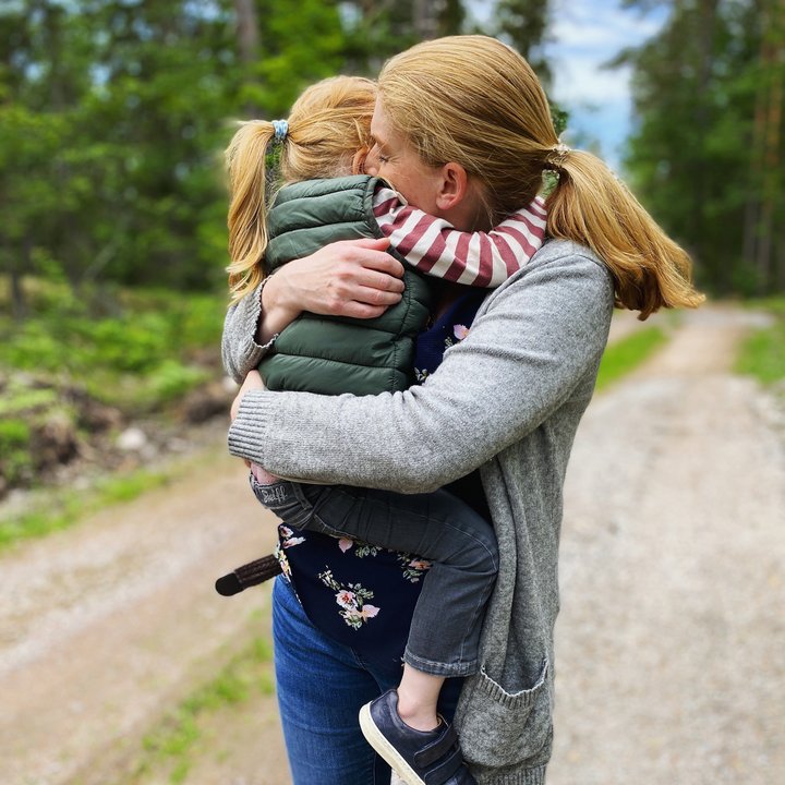 Eine Mutter hält ihr Kind auf dem Arm.